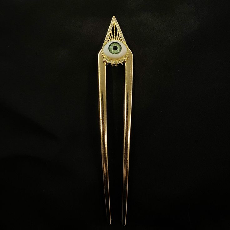 "Pieces are attached using a special jewelry adhesive. Please read descriptions thoroughly for sizes and materials.  This is a cute u shaped gold metal hair fork, featuring a white and blue green glass eye, with an ornate gold metal bezel, with small glass faceted gems beneath the eye and at the edges of the triangular ornament at the top. This a really fun way to dress up any hair style, and especially eye catching for a formal hair style, Halloween, or when you want people to see that you have Creepy Jewelry, Hair Accessories Bun, Creepy Eyes, U Shaped Hair, Blue Green Eyes, Formal Hair, Realistic Eye, Blue Iris, Green Eye