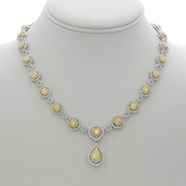 Navigate the nuances of elegance with our Hanging Pear Two Tone Diamond Necklace. Crafted for the soulful romantic in you, this necklace embodies the perfect blend of sophistication and allure. Picture this: glistening white and yellow diamonds, totaling a mesmerizing 13.12 carats, grace the entire neckline of this exquisite 18K gold masterpiece. Amidst the cascade of diamonds, a resplendent pear-shaped yellow diamond steals the spotlight, casting a warm glow that captures the heart.Imagine adorning yourself with this necklace, the embodiment of timeless love and captivating grace. The pear-shaped yellow diamond, delicately prong-set, hangs gracefully from the center, embraced by a halo of dazzling white diamonds. Each facet of this pendant tells a story, a tale of love and passion that li Exquisite Pear-shaped Necklace For Anniversary, Luxury Yellow Necklaces With Diamond Accents, Exquisite Pear-shaped Anniversary Necklace, Luxury Yellow Necklace With Diamond Accents, Luxury White Gold Pear-shaped Necklace, Luxury Pear-shaped White Gold Necklace, Luxury Teardrop Necklace With Elegant Design, Anniversary Pear-shaped Necklace With 17 Jewels, Formal Yellow Diamond Necklace Fine Jewelry Style