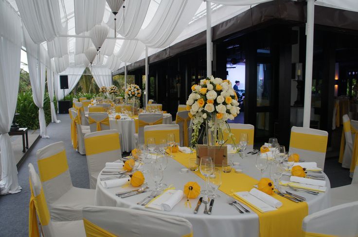 the tables are set with yellow and white linens