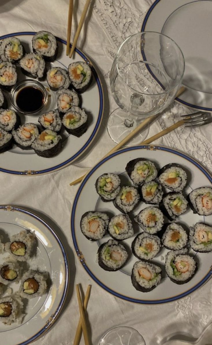 three plates with sushi and chopsticks on them