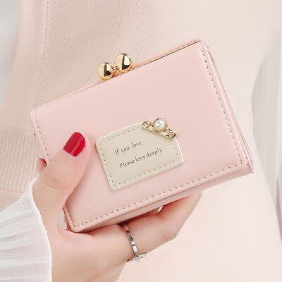 a woman holding a pink purse with a tag on it