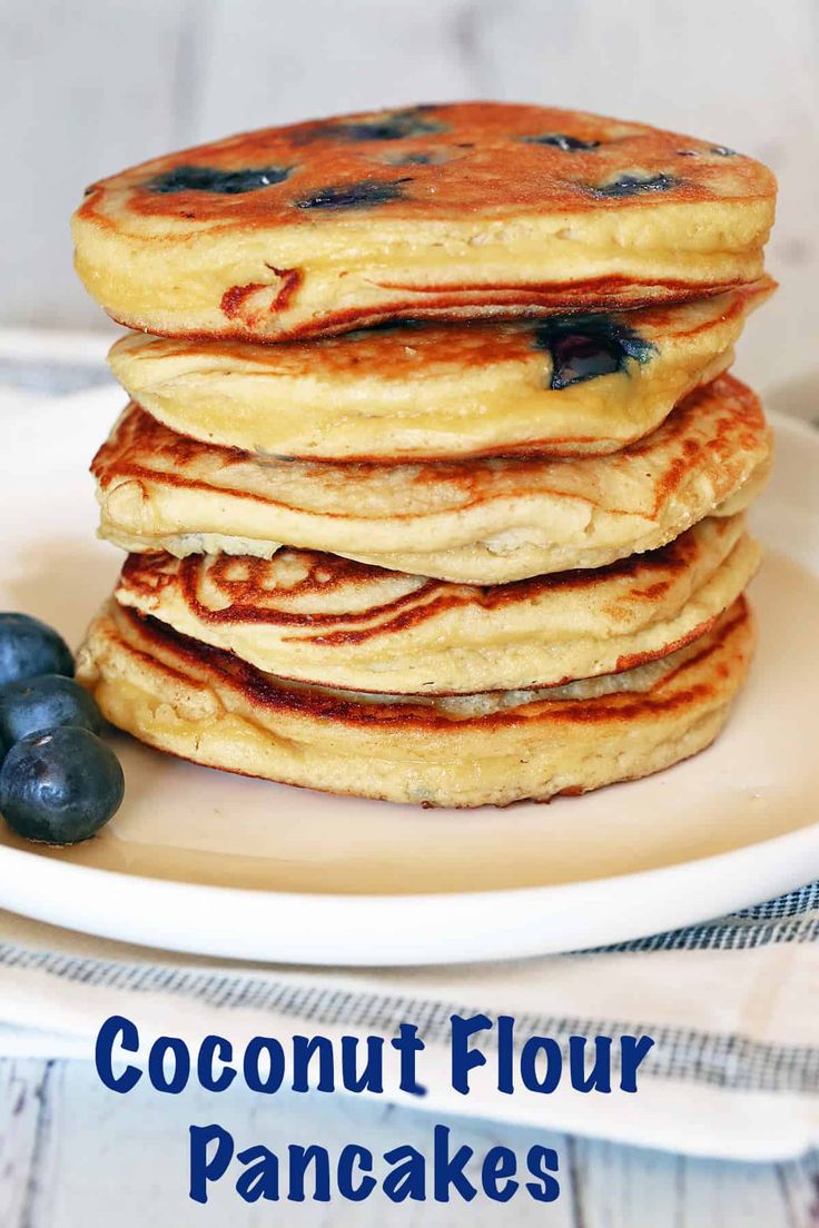 stack of coconut flour pancakes with blueberries on the side and text overlay reading coconut flour pancakes