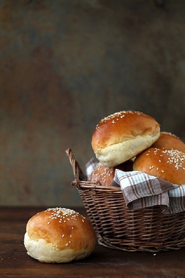 bread rolls in a basket on a wooden table