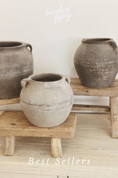 two vases sitting on top of a wooden bench