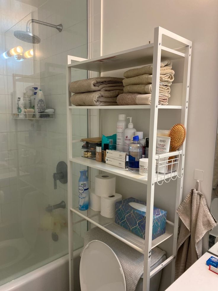 a bathroom with white shelving and shelves filled with toiletries