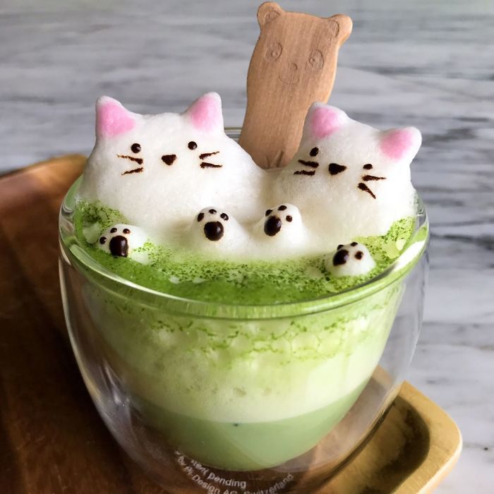 three white cats in a green liquid with black dots on their eyes and ears, sitting next to each other