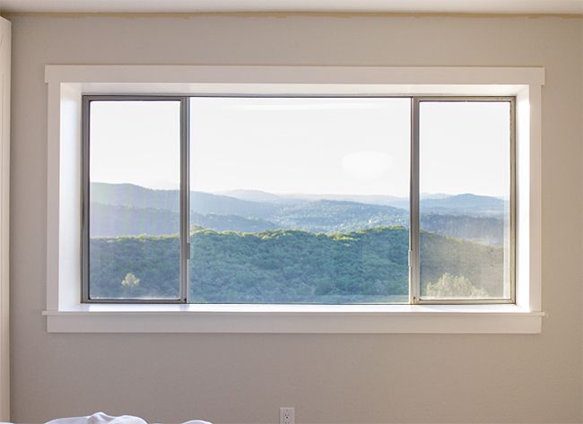 a bedroom with a large window overlooking the mountains