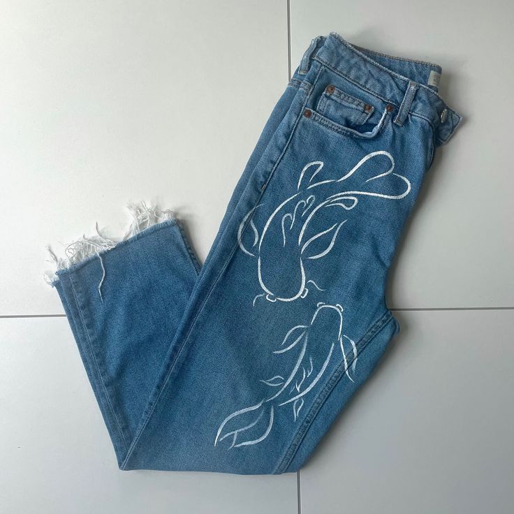 a pair of blue jeans with white drawings on them