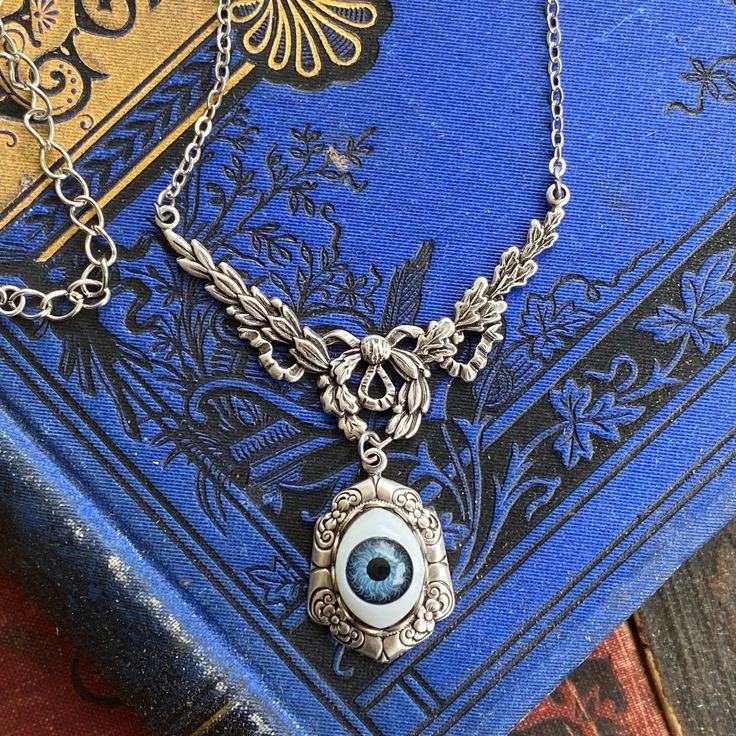 "Doll eye ball in elegant filigree setting. - Choose antique brass or antique silver. - Choose eye color: green, blue or brown. The length is adjustable between 16\"-18\" but I can make it any length by request, just leave me a note at checkout. I also have matching rings and earrings in my shop Matching Ring: https://www.etsy.com/listing/858164435/eye-ring-vintage-style-adjustable-green" Taurus Ring, Oddities Jewelry, Ball Pendant Necklace, Eye Ball, Brown Eye, Cameo Ring, Bib Necklaces, Ball Pendant, Doll Eyes