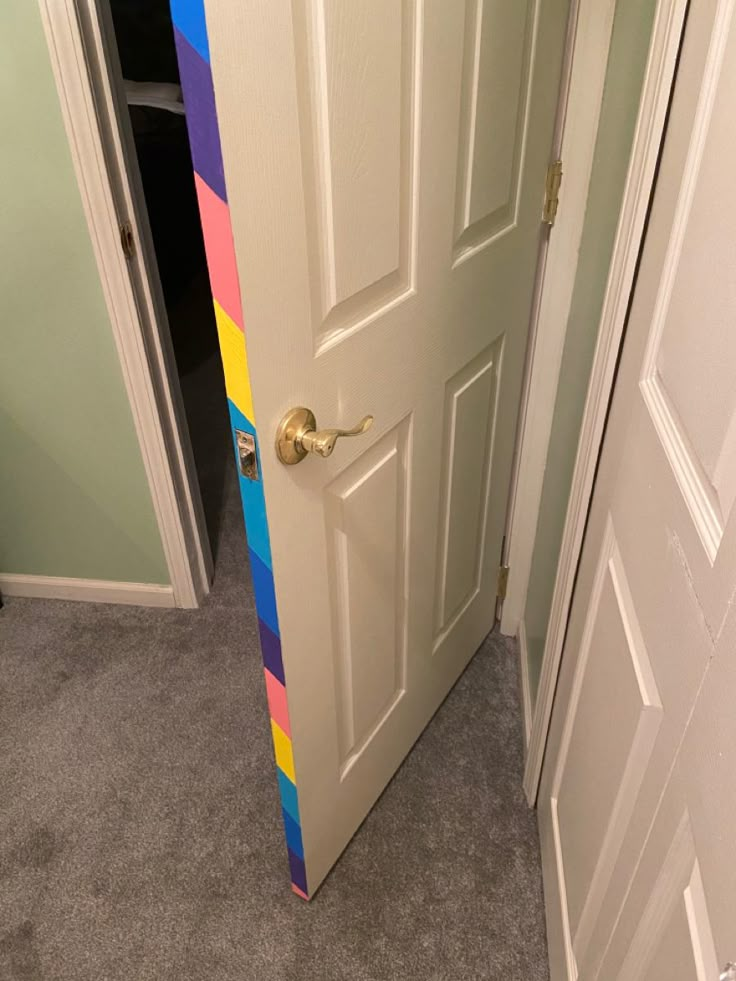 an open door with a multicolored strip painted on the front and back side