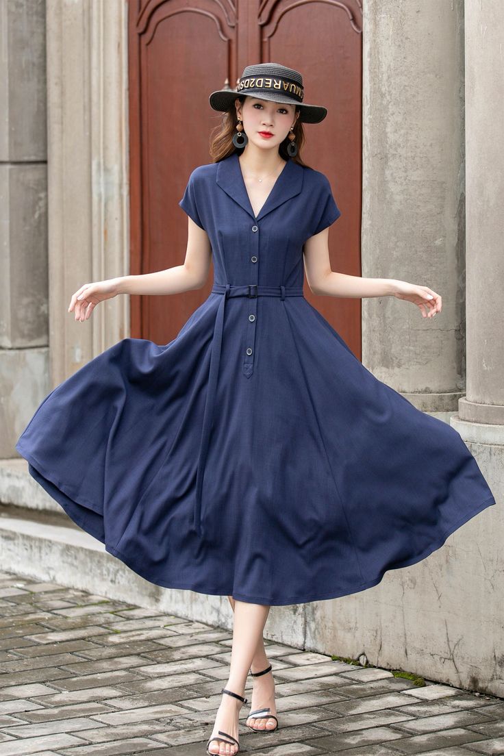 "This vintage-inspired short-sleeved shirt dress is the perfect addition to any retro lover's wardrobe! Featuring a classic collared neckline, front button closure, and a flattering A-line silhouette, this dress is both timeless and trendy. The elegant shade of blue is sure to turn heads and the lightweight fabric makes it perfect for warmer weather. DETAILS *  100% linen *  Two side pockets *  Front Button up closure *  Belted dress *  Short sleeve *  Notched collar *  Below knee Length *  Perf 1950s Style A-line Vintage Dress With Buttons, Spring Dresses With Short Sleeves In 1950s Style, 1950s Style Short Sleeve Spring Dresses, 1950s Style Short Sleeve Dresses For Spring, 1950s Style Summer Dress With Short Sleeves, Classic Short Sleeve Dress With Button Closure, Vintage 1950s Collared Dress, Fitted Vintage Dress With Short Sleeves, Retro Short Sleeve Midi Dress For Spring