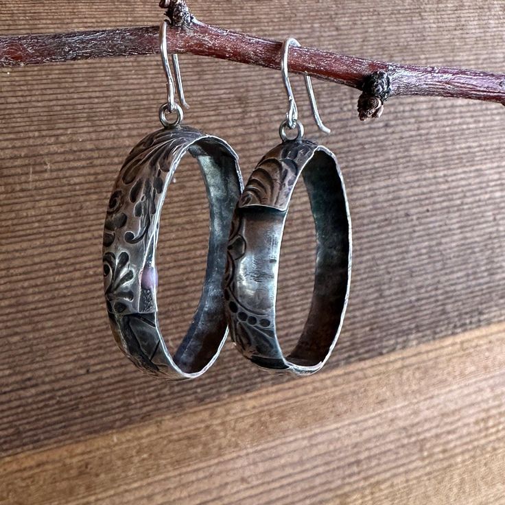 Add a touch of sophisticated Western style to your everyday look with our Prairie Hoops. These solid sterling silver hoop earrings feature a unique tooled leather texture that is both eye-catching and timeless. The medium statement size is perfect for dressing up or down, making them a versatile addition to your jewelry collection. Crafted from high-quality materials, the Prairie Hoops are built to last. The sterling silver earwire is nickel-free and hypoallergenic, so you can wear them comfortably all day long. The tooled leather texture is hand-applied, giving each pair of earrings a unique look. Whether you're dressing up for a night out or adding a touch of flair to your everyday style, the Prairie Hoops are sure to turn heads. Artisan Oxidized Finish Earrings For Everyday, Vintage Small Hoop Sterling Silver Jewelry, Artisan Sterling Silver Etched Earrings, Sterling Silver Engraved Hoop Earrings For Anniversary, Artisan Etched Sterling Silver Earrings, Vintage Etched Earrings, Silver Engraved Hoop Earrings For Anniversary, Engraved Sterling Silver Adjustable Earrings, Engraved Sterling Silver Hoop Earrings For Anniversary