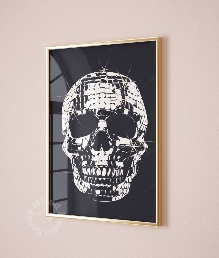 a framed photograph of a skull in black and white on a pink wall with gold trim