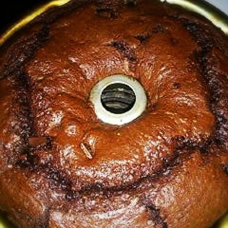 a chocolate bundt cake sitting on top of a yellow pan with a hole in the middle