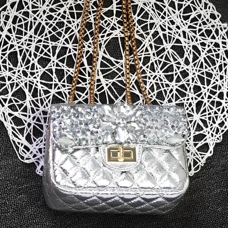 Get ready to slay any outfit with the Erica Fragrance Clutch Bag! Sparkling rhinestones, timeless design, and impeccable craftsmanship make this bag a conversation starter wherever you are. Its high-quality materials make it durable, and its luxurious design makes it the centre of attention. Make a statement with this phenomenal clutch bag! Exclusively available in silver. Luxury Pouch Bags As Fashion Accessory, Luxury Silver Bag With Chain Strap, Luxury Silver Bags With Chain Strap, Luxury Silver Crossbody Shoulder Bag, Luxury Silver Shoulder Bag With Chain Strap, Designer Silver Shoulder Bag As Gift, Designer Silver Shoulder Bag Gift, Luxury Silver Clutch Shoulder Bag, Silver Luxury Clutch Shoulder Bag