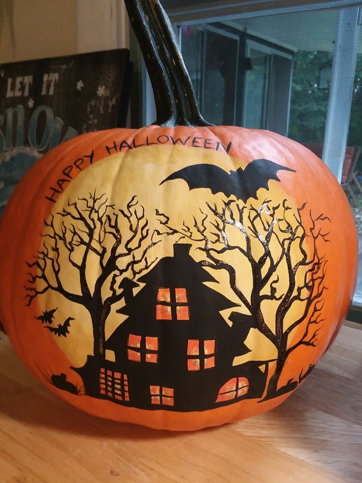 a carved pumpkin with a house and bats on it