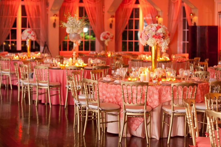 the tables are set up with pink linens and gold chairs for an elegant wedding reception