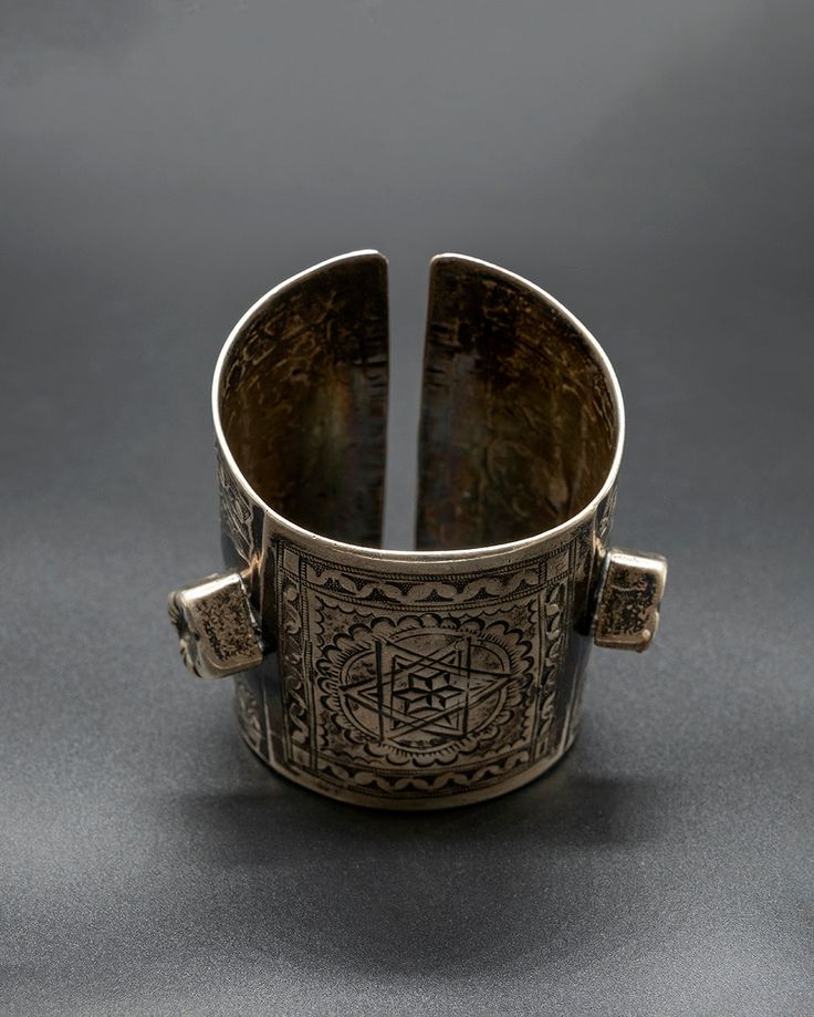 Make a statement with our exquisite Libya Cuff, a true testament to the unparalleled beauty of traditional tribal jewelry. Meticulously crafted from high-quality sterling silver and featuring intricate hand-carved detailing, this vintage cuff from Libya is a true work of art. 217 grams of silver This item will ship directly from Bali via DHL delivery. Please allow up to 15 business days to arrive. Ceremonial Engraved Brass Cuff Bracelet, Antique Silver Brass Bracelet, Ceremonial Etched Metal Jewelry, Vintage Silver Carved Jewelry, Vintage Carved Silver Jewelry, Antique Oxidized Finish Cuff Bracelet As Gift, Antique Oxidized Cuff Bracelet As Gift, Antique Oxidized Cuff Bracelet For Gift, Bohemian Carved Sterling Silver Jewelry