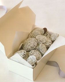 a box filled with donuts sitting on top of a white table next to a cup