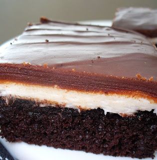 a piece of chocolate cake sitting on top of a white plate covered in frosting