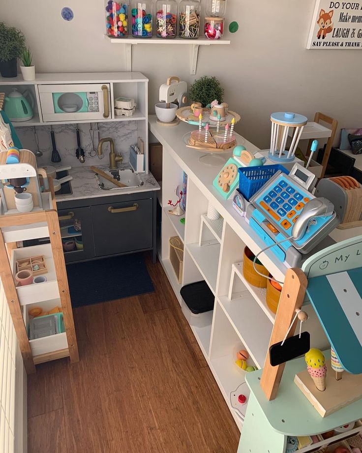 a toy kitchen and playroom in a child's room