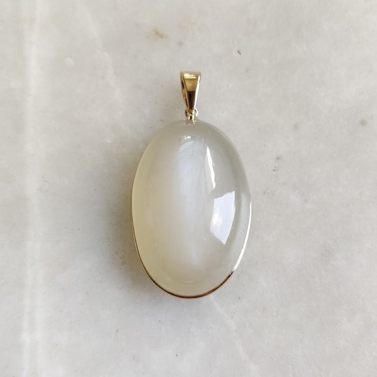 Details of the pendants: White Moonstone Pendant Stone Weight: 29.05 carats Stone size and shape: 20x30 mm & Oval Metal: GOLD Purity: 14K (58.33%) approx Gold Weight: 0.76 grams Gross Weight: 6.57 grams White Moonstone necklace pendant. These pendants are absolutely perfect for daily wear as they are light and definitely stylish. This dainty pendant can be used in layers with other pendants. The initial price is for pendant only, For chain along with the pendant for the necklace, please see the White Gemstones Fine Jewelry As Gift, White Gemstones For Gifts, Fine Jewelry Style, White Gemstones For Gifts In Fine Jewelry Style, White Birthstone Gemstones For Gifts, Elegant Moonstone Gemstones Gift, Elegant White Jewelry With Large Stone, Elegant White Necklaces With Large Stone, White Chalcedony Jewelry For Anniversary, Classic White Moonstone Jewelry