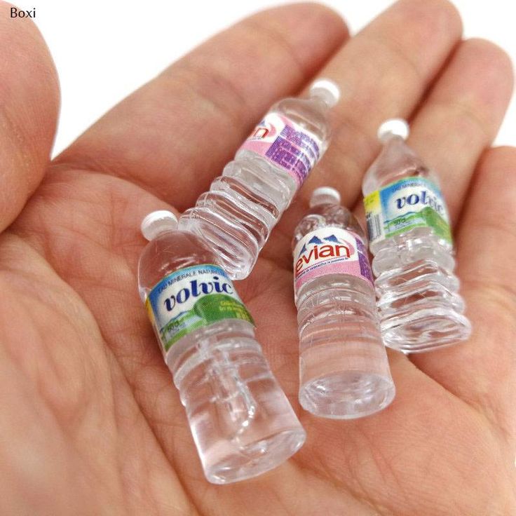 three small plastic water bottles in the palm of someone's hand