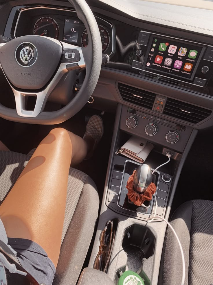 a person sitting in the driver's seat of a car with their feet on the steering wheel