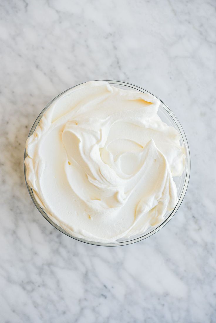 a bowl filled with whipped cream on top of a marble counter