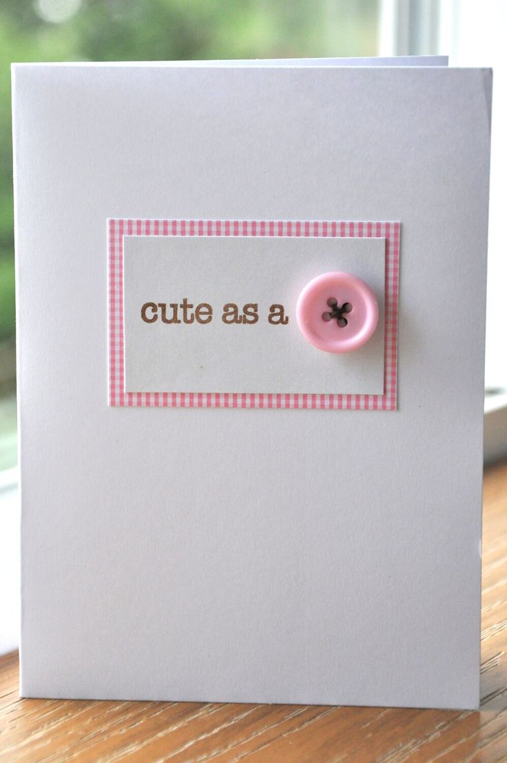 a white card with a pink button on it that says cute as a button in front of a window