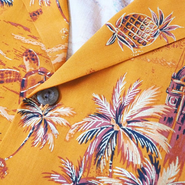 an orange shirt with palm trees on it and a clock tower in the back ground