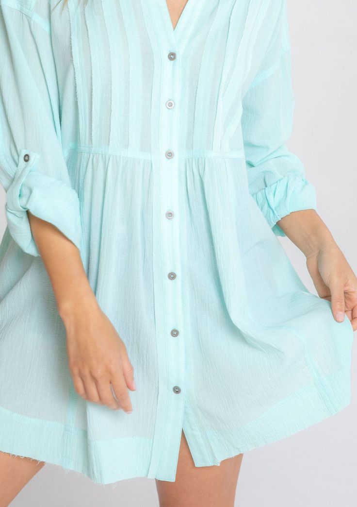 Ultra-relaxed and flowy, this effortless tunic top is our go-to style for any season. Featuring long rolled sleeves with a button tab closure, pintuck front details, and a button-up front. The raw edge hemline adds a lived-in feel. Tunic shirt Relaxed, oversize fit Long rolled sleeve with button tab closure Long tunic length Collared neckline Button front Raw-edge hem Side pockets Pintuck details Sheer Cotton Spring top Model is 5'9, wearing a size S/M.Style: I-13929W-RUU Summer Tunic Blouse With Buttons, Casual Spring Tunic Shirt, Spring Buttoned Tunic Top, Spring Button Tunic Top, Spring Tunic Top With Buttons, Casual Tunic Blouse With Buttons, Chic Button-up Tunic For Spring, Casual Tunic With 3/4 Sleeve And Relaxed Fit, Spring Casual Tunic With 3/4 Sleeves