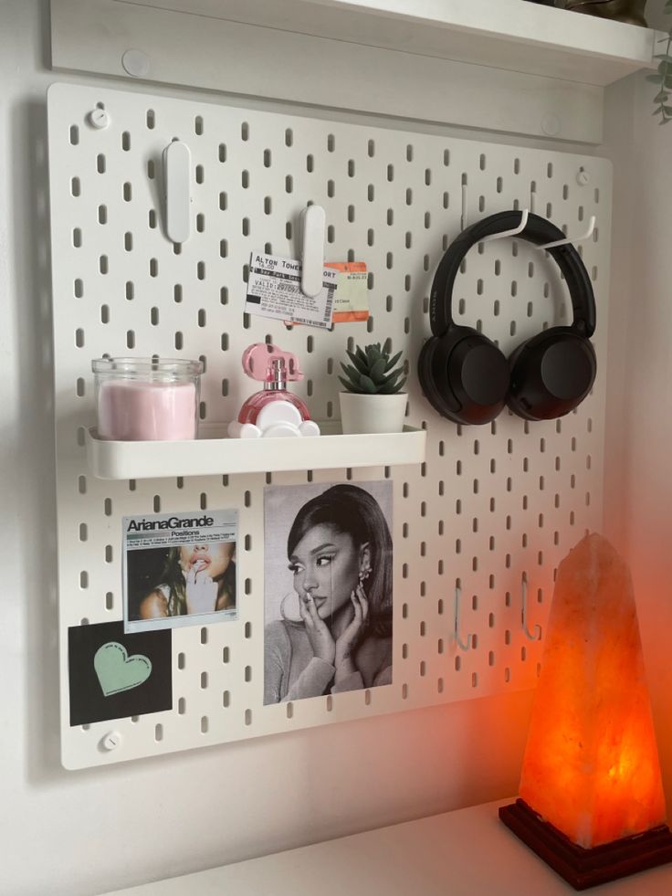 a white shelf with headphones and pictures on it