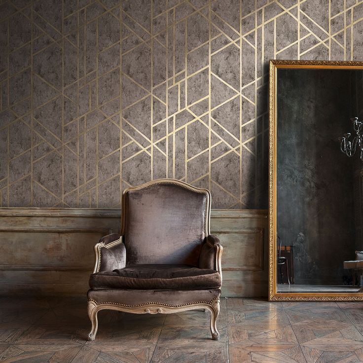 an old chair sitting in front of a large mirror on the floor next to a wall