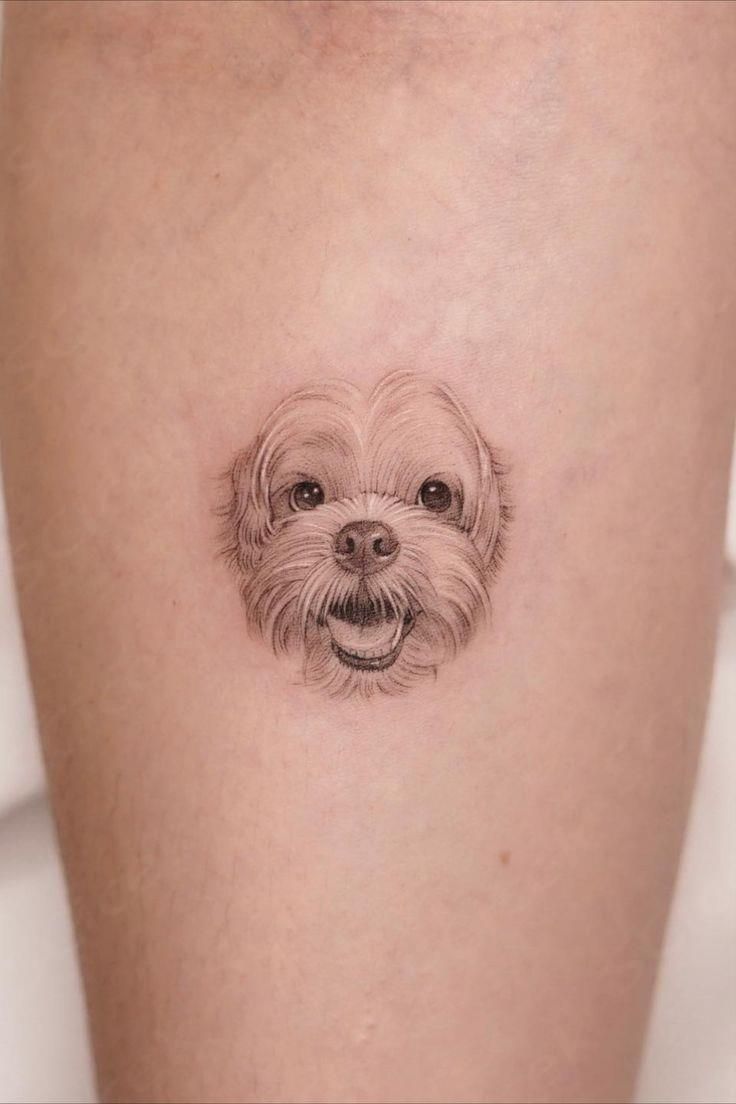 a small dog's face is shown on the thigh