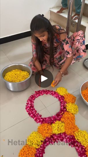 a woman kneeling down next to bowls filled with flowers