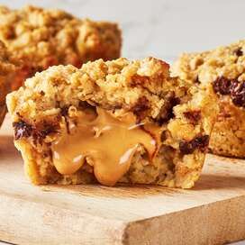 two muffins sitting on top of a wooden cutting board