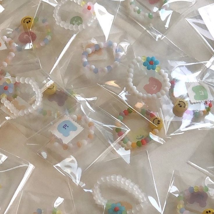 plastic bags filled with lots of different types of buttons and beads on top of each other