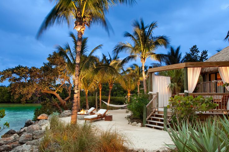 an image of a beach resort with palm trees and water in the background that says little palm island which means welcoming guests back