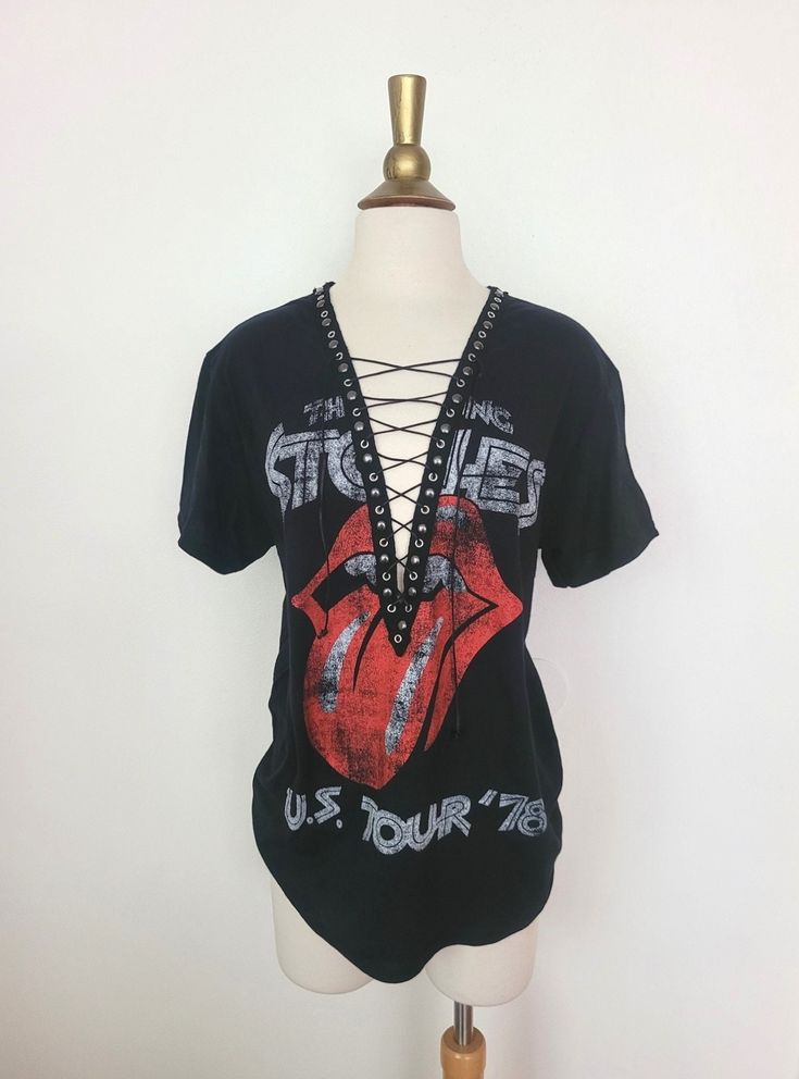 "Rolling Stones Lace Up T-Shirt with Gunmetal Studs Detailed Trim Each piece is uniquely designed and one of its' kind. Hand stitched edge detailing for superior quality and unique finish. Please note, since this is a handmade item, there may be slight variances with each T.  UNISEX Sizing (women may choose to size down depending on fit preference) Pictured size M on M form, for reference. Appx. Measurements Laying Flat: S: 17\" across chest Width x 28\" Length M: 19\" across chest Width x 29\" Length L: 21\" across chest Width x 31\" Length XL: 23\" across chest Width x 32\" Length XXL: 25\" across chest Width x 33\" Length ** If you have a custom idea or would like to mix and match a design idea seen in my shop, feel free to contact me anytime **" Spring Grunge T-shirt For Alternative Fashion, Summer Rock T-shirt With Band Logo, Edgy Festival T-shirt With Crew Neck, Vintage Distressed T-shirt For Festivals, Spring Rock Style Crew Neck T-shirt, Distressed Punk T-shirt, Distressed Rock T-shirt For Streetwear, Distressed Punk Tops For Summer, Edgy Acid Wash T-shirt For Alternative Fashion