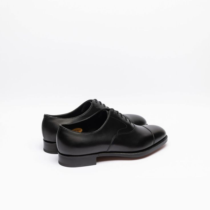 Black calf oxford shoe with stitched cap toe, double leather sole. Fitting F, last 202. Made in England Timeless Goodyear Welted Oxfords For Derby, Timeless Oxford Shoes For Business, Leather Oxfords With Leather Sole For Derby, Goodyear Welted Oxford Dress Shoes, Timeless Plain Toe Goodyear Welted Oxfords, Timeless Oxfords With Rubber Sole, Classic Lace-up Oxford Shoes With Goodyear Welted, Classic Goodyear Welted Lace-up Shoes, Goodyear Welted Oxford Dress Shoes With Almond Toe