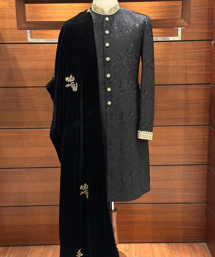 With our stunning Black Embroidered Sherwani for men, you can exude sophistication while combining classic style and contemporary appeal. The entire sherwani is covered in an exquisite floral design that is painstakingly embroidered onto the opulent silk fabric. Finished with zardozi embroidery by hand on the collar and cuffs, this piece exudes subtle elegance. The dispersed flower embroidery adds a classic and elegant appearance, resulting in a tasteful blend of traditional and modern design el Ceremonial Elegant Semi-stitched Sherwani, Elegant Semi-stitched Sherwani With Dabka Work, Elegant Sherwani With Intricate Embroidery In Jamawar, Elegant Jamawar Sherwani With Intricate Embroidery, Elegant Designer Sherwani With Dupatta, Luxury Bandhgala For Groom, Black Semi-stitched Elegant Sherwani, Elegant Black Semi-stitched Sherwani, Elegant Semi-stitched Bandhgala With Dupatta