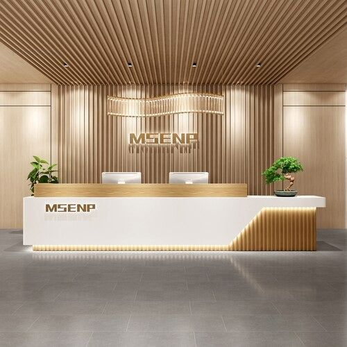 an empty reception area with wood paneling on the walls and white counter tops, along with potted plants