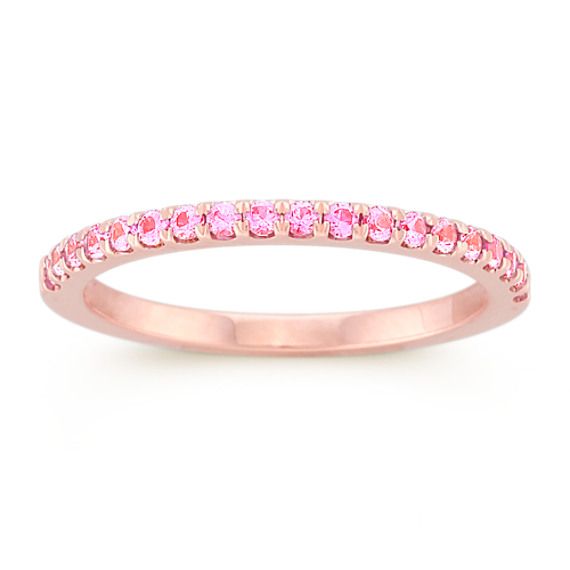 This utterly feminine wedding band features 19 round pavé-set pink sapphires at approximately .28 carat total weight. Each stone has been hand-selected for maximum color and sparkle. The ring is crafted from quality 14 karat rose gold. Pink Eternity Band With Prong Setting As Promise Ring, Pink Sapphire Stackable Ring In Fine Jewelry Style, Pink Sapphire Stackable Ring For Anniversary, Fine Jewelry Pink Sapphire Diamond Ring In Pink Gold, Fine Jewelry Pink Gold Diamond Ring With Pink Sapphire, Elegant Pink Sapphire Stackable Ring, Pink Diamond Ring With Round Band In Fine Jewelry, Pink Eternity Band With Prong Setting, Fine Jewelry Pink Diamond Ring With Round Band