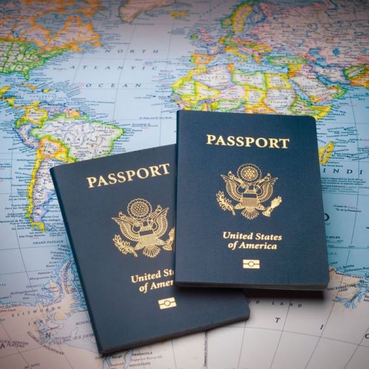 two passports sitting on top of a map