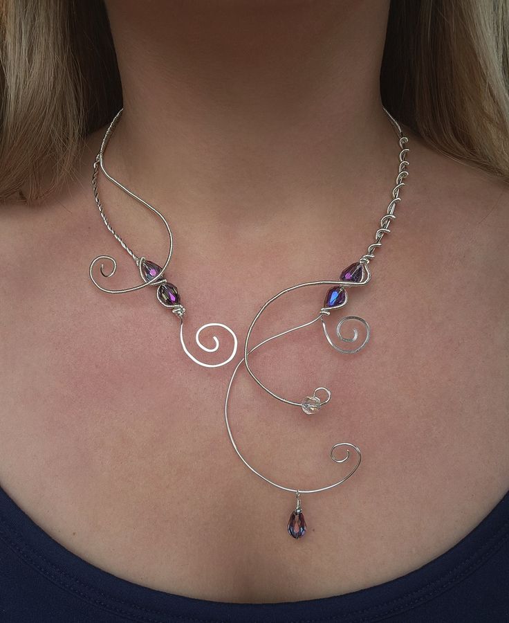 a woman wearing a silver necklace with purple beads