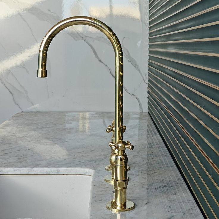 a gold faucet on a marble counter top