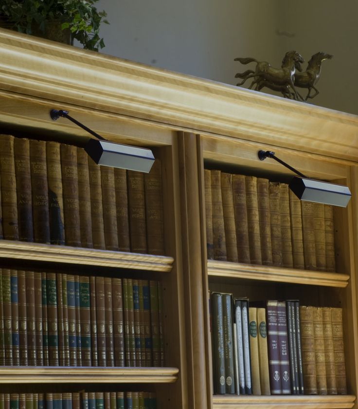 a bookshelf filled with lots of books next to a lamp