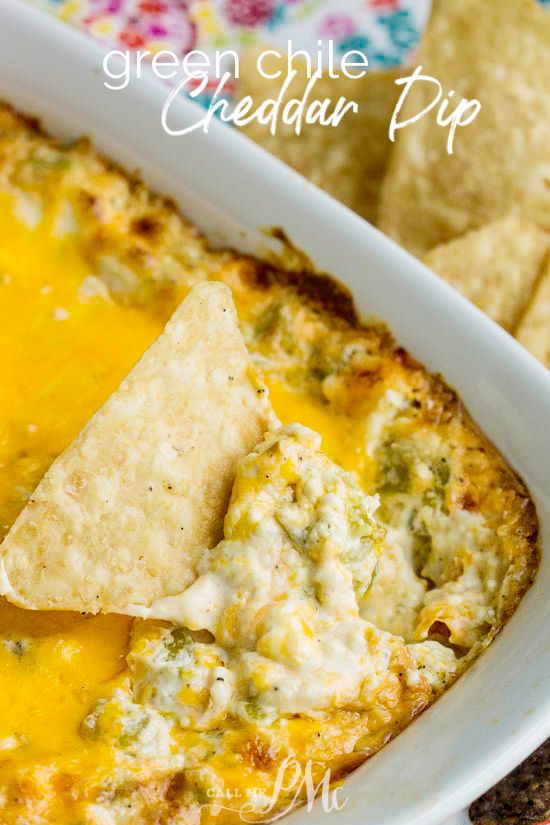 green chile cheddar dip in a white casserole dish with tortilla chips