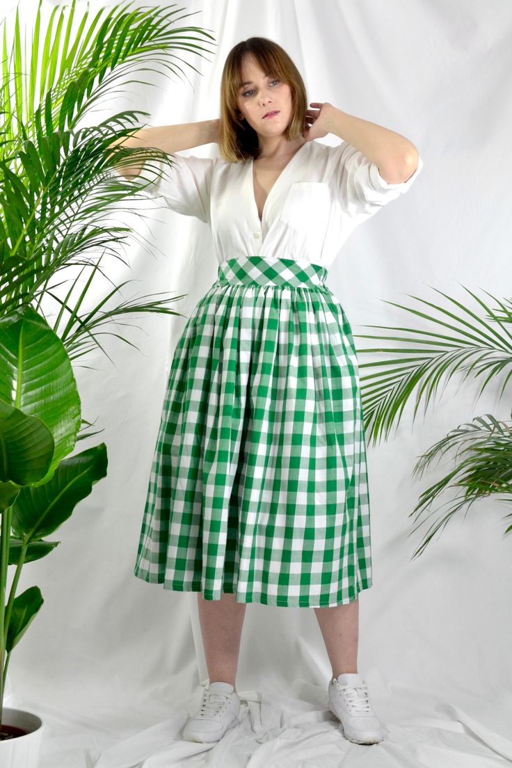 Green check high waist full gathered skirt. Perfect for casual outfits and special ocasions with pair of trainters or high heels. 100% cotton.  Elastic at the back of waist.  Two side pockets. Midi lenght about 70cm + 5 cm waistband. Handmade in UK.  Model wears size S.  HOW TO CHOOSE A SIZE ?   Using a measuring tape, measure the smallest part of your waist.  SIZE CHART: (CM) XS - W: 66 CM S - W: 70 CM M - W: 74 CM  L - W: 78 CM  XL - W: 82 CM  CARE INSTRUCTIONS: Hand wash only, do not bleach, Casual Gingham Gathered Skirt, Summer Cotton Pleated Skirt For Daywear, Cotton Summer Pleated Skirt For Daywear, Summer Daywear Cotton Pleated Skirt, Gingham Gathered Skirt Bottoms For Spring, Spring Gingham Gathered Skirt Bottoms, Gingham Gathered Skirt For Spring, Classic Cotton Bottoms With Voluminous Skirt, Gingham Skirt For Summer Picnic